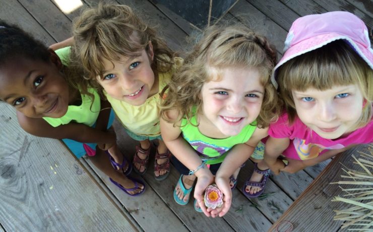 Four children look up at the camera.