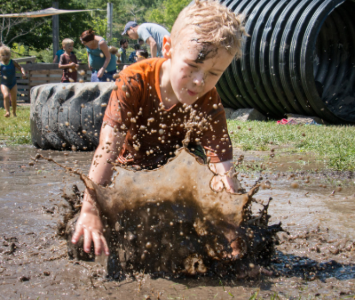 Child splashing in a large mud puddle