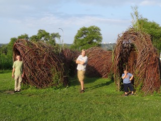 Three boys play in the willow sculpture.