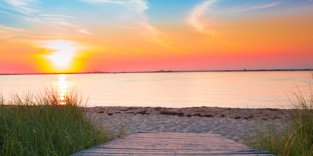 A photo of a sandy beach at sunset.