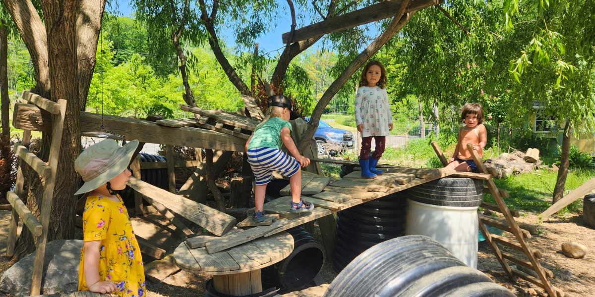 Four young kids climb atop a structure crafted by ICG's After School program attendees.
