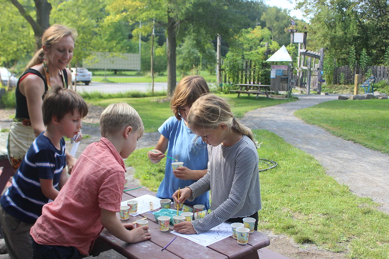 A group of kids use soil they gathered to paint pictures at Ithaca Children's Garden's After School program, with Bailey Colvin from Cornell Small Farms, facilitating.
